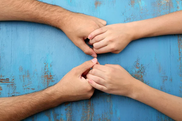 Amante casal de mãos dadas close-up no fundo de madeira — Fotografia de Stock