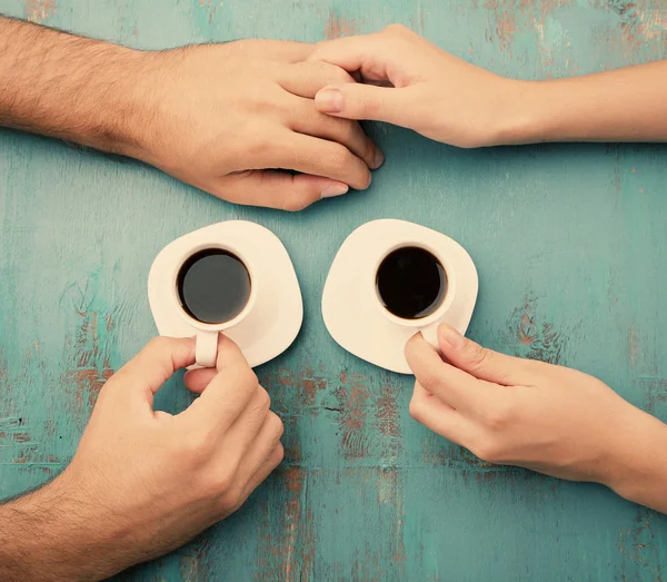 Tazas de café y de la mano en la mesa de madera —  Fotos de Stock