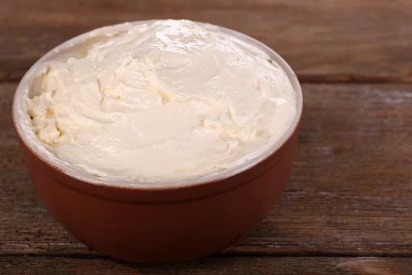 Frische hausgemachte Butter in Schüssel, auf Holzgrund — Stockfoto