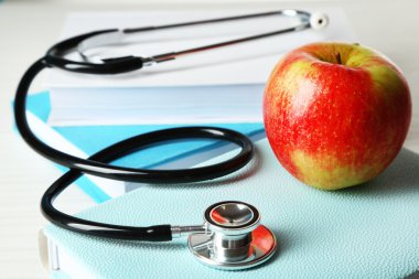 Ahşap masa kitap üzerinde apple ile sağlık stetoskop