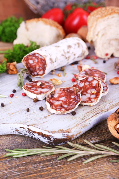 フランスのトマト、パセリ、木製の背景にまな板の上のパンとサラミ — ストック写真