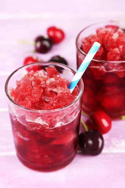 Primo piano di granita ciliegia in bicchieri, su sfondo di legno a colori — Foto Stock