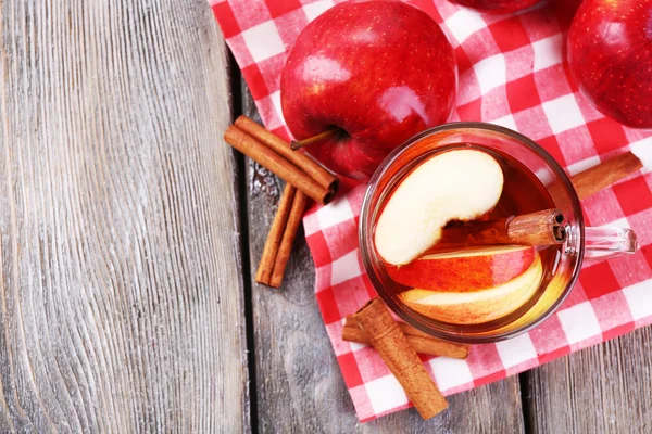 Apple cider met kaneelstokjes en verse appelen op houten achtergrond — Stockfoto