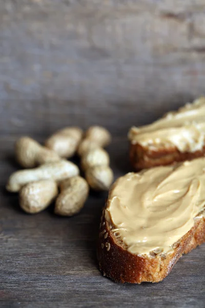 Tasty sandwiches with fresh peanut butter on wooden background — Stock Photo, Image