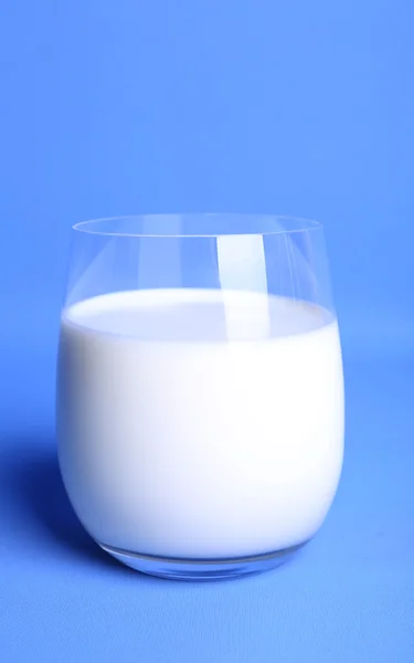 นมในแก้วบนพื้นหลังสีฟ้า — ภาพถ่ายสต็อก