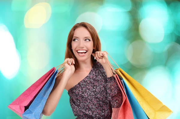 Conceito de compras. Mulher bonita com sacos de compras no fundo brilhante — Fotografia de Stock