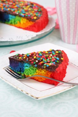 lezzetli gökkuşağı pasta tabak ve bardak kahve, masada açık renkli