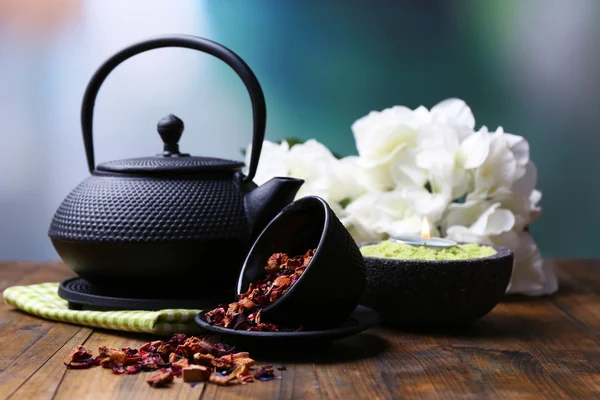 Black teapot, bowl and hibiscus tea on color wooden table, on bright background — Stock Photo, Image