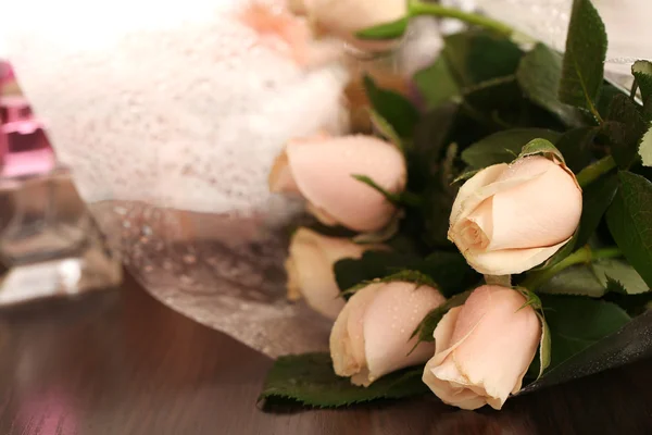 Mooie rozen, parfums op tafel in de buurt van spiegel — Stockfoto