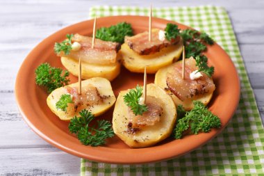 fırında patates tabakta ahşap zemin üzerine pastırma ile