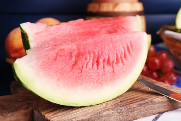 Komposisi semangka matang, buah-buahan, anggur merah muda dalam tong kaca dan kayu pada latar belakang kayu — Stok Foto