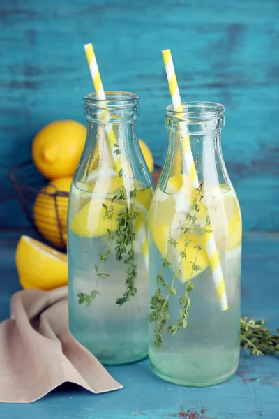 Tasty cool beverage with lemon and thyme, on wooden background — Zdjęcie stockowe