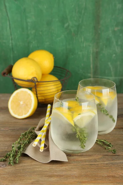 Sabrosa bebida fresca con limón y tomillo, sobre fondo de madera —  Fotos de Stock