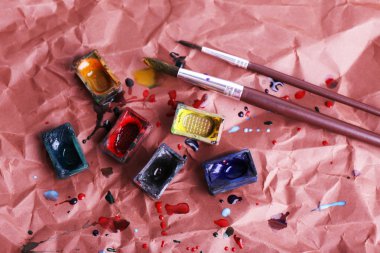 Suluboya boya küpleri fırçalar ve dökülen boya ile