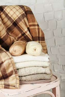 Ahşap sandalye üzerinde iplik ve giysileri örgü ile natürmort