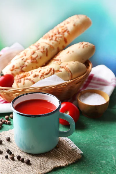 Zelfgemaakte tomatensap in kleur mok, brood stokken, specerijen en verse tomaten op houten tafel, op helder — Stockfoto