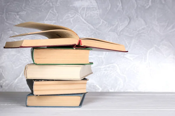 Livros sobre mesa de madeira no fundo claro — Fotografia de Stock