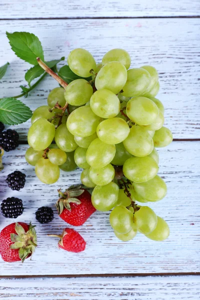 Farklı meyveler ve ahşap masa yakın çekim üzüm — Stok fotoğraf