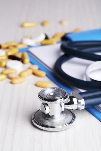 Estetoscopio, pastillas, botellas sobre fondo de madera. concepto de medicina —  Fotos de Stock