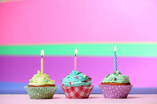 Deliciosos cupcakes de aniversário na mesa em fundo brilhante — Fotografia de Stock