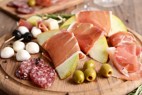 Delicious melon with prosciutto on table close-up — Stock Photo, Image