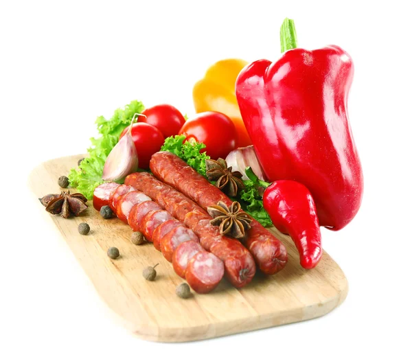 Копчені тонкі ковбаски та овочі на обробній дошці, ізольовані на білому — стокове фото