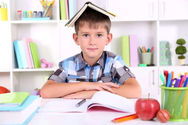 Écolier assis à table dans la salle de classe — Photo