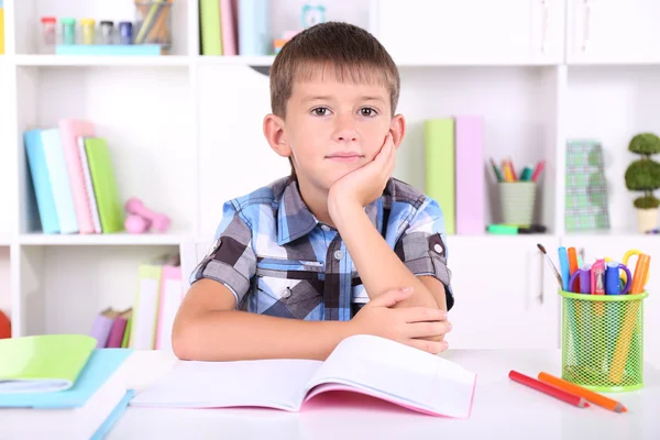 школяр, сидячи на столі в класі