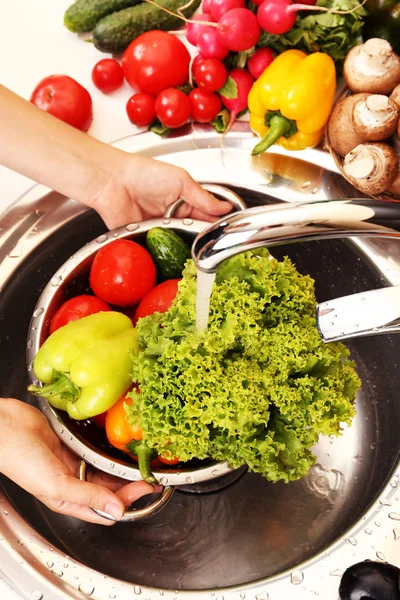 Vrouw handen wassen groenten in zinken in keuken — Stockfoto