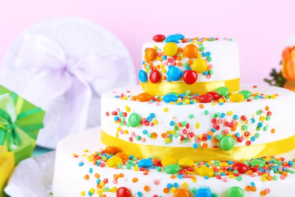 Güzel lezzetli pasta ve renkli arka plan üzerinde hediyeler — Stok fotoğraf