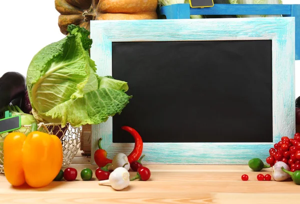 Verduras orgánicas frescas con pizarra en la mesa de madera, de cerca —  Fotos de Stock