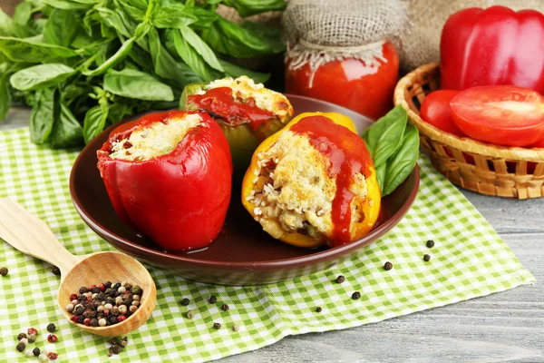 Σύνθεση με έτοιμη γεμιστές πιπεριές για πλάκα και φρέσκα βότανα, καρυκεύματα και λαχανικά, σε ξύλινο φόντο — Φωτογραφία Αρχείου