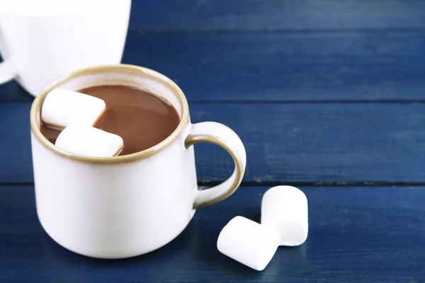 Chocolate caliente con malvaviscos en taza, sobre fondo de madera —  Fotos de Stock