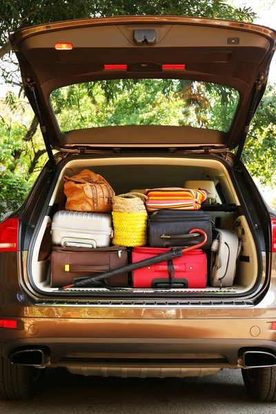 Maletas y bolsas en maletero de coche listas para salir de vacaciones — Foto de Stock