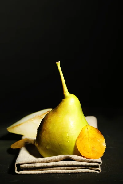 Ripe tasty pear on wooden table, on dark background — Stock Photo, Image