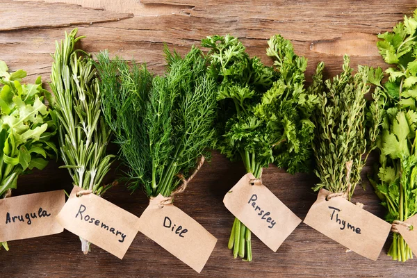 Different fresh herbs on wooden background — Stock Photo, Image