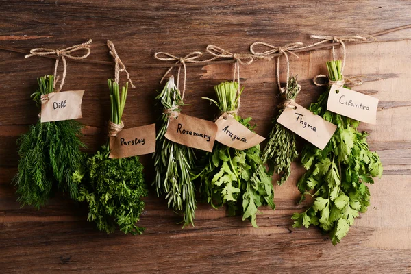 Different fresh herbs on wooden background — Stock Photo, Image