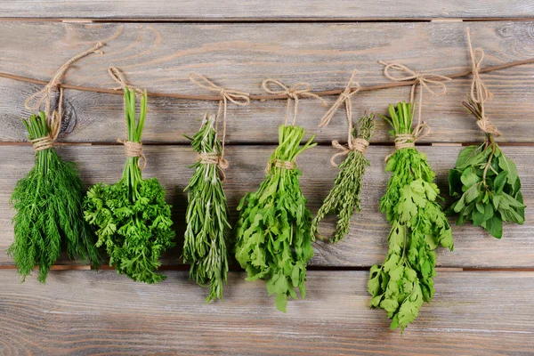 Verschiedene frische Kräuter auf Holzgrund — Stockfoto