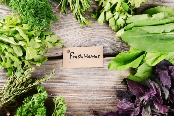 Different fresh herbs on wooden background — Stock Photo, Image