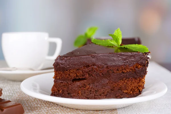 Stücke Schokoladenkuchen auf Tellern auf dem Tisch vor natürlichem Hintergrund — Stockfoto