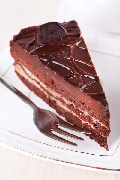 Pedaço de bolo de chocolate na placa na mesa de madeira no fundo bule — Fotografia de Stock