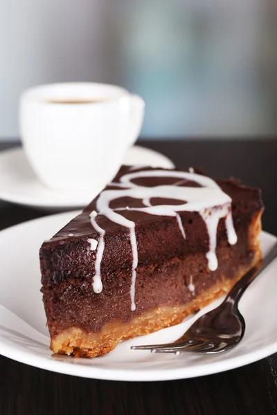 Pezzo di torta al cioccolato sul piatto e tazza di tè sul tavolo di legno su sfondo naturale — Foto Stock