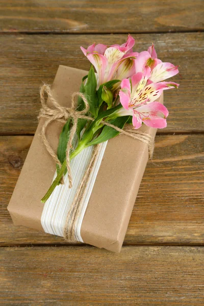 Természetes stílusú kézműves ajándék doboz-val friss virágok és rusztikus zsineg, fából készült háttér — Stock Fotó
