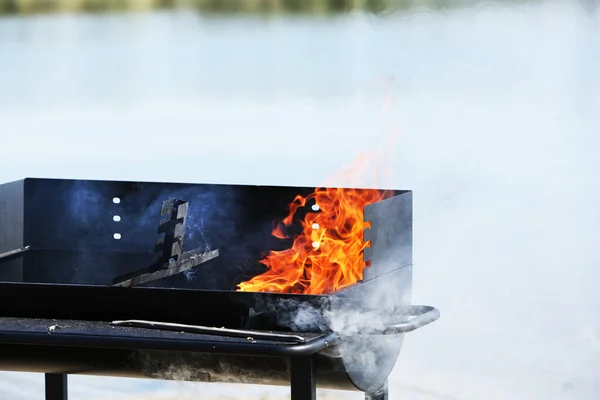Barbecue grill on beach of river — Stock Photo, Image