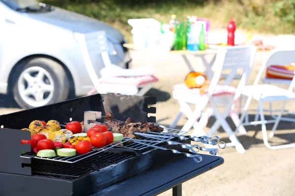 Skewers and vegetables on barbecue grill, close-up — Stock Photo, Image