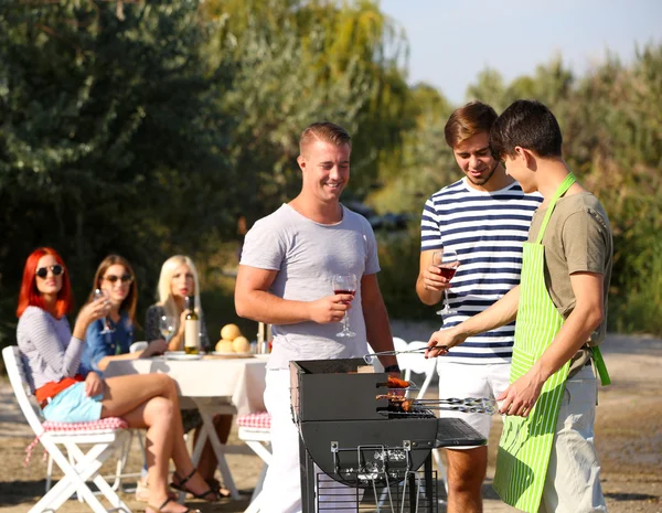 Unge venner som har grillfest, ute – stockfoto