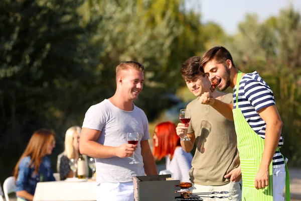 Young friends having barbecue party, outdoors