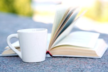 Sıcak bir içecek ve kitap ile Kupası
