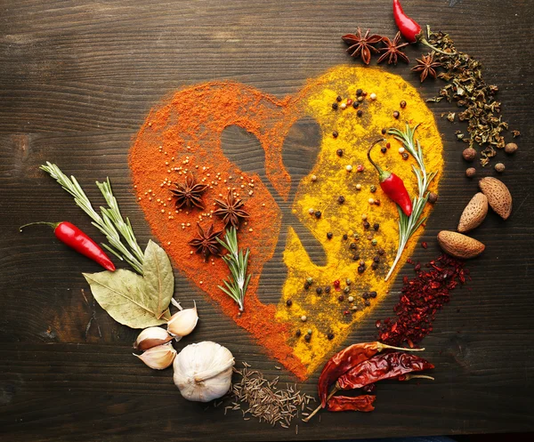Especiarias na mesa em forma de coração com silhueta de colher, close-up — Fotografia de Stock