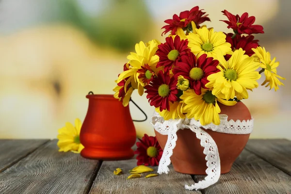 Prachtig chrysanthemum in pot met kandelaar op tafel op lichte achtergrond — Stockfoto